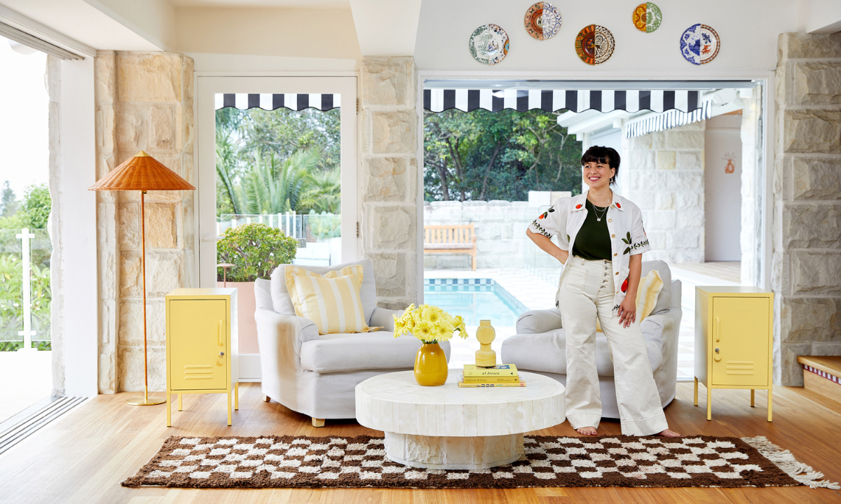 Becca stands in a beautifully styled home with two Butter Shortys either side of her. There is a pool outside in the background.