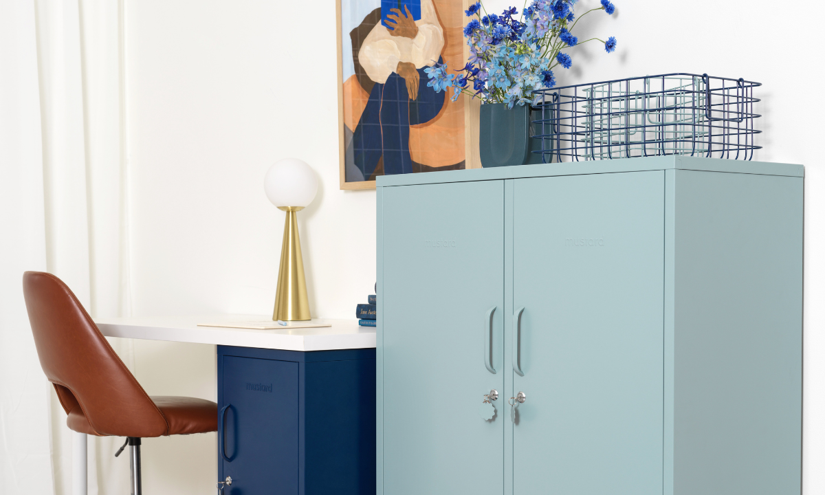 An Ocean Midi sits next to a desk and office chair in a stylish workspace. There is a blue and earthy toned artwork on the wall.