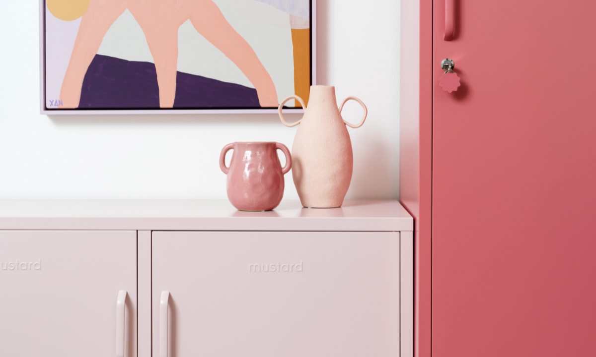 A Berry Skinny stands next to a Blush Lowdown with two pale pink vases on top. There is an abstract painting hanging on the wall in shades of pink and purple.